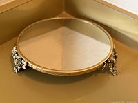 Full view of round mirrored plateau showing slanted side