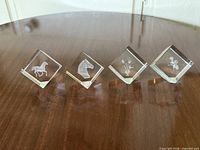 Four crystal cubes with various etchings displayed