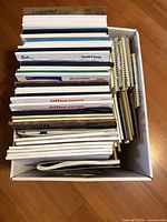 Top view of box filled with assorted legal pads, notepads, steno pads