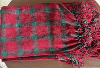 Throw blanket folded on table showing overall plaid pattern and fringe