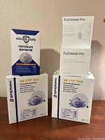 Five sealed respirator, mask and filter boxes on table