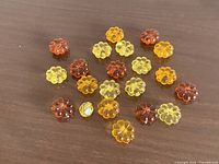 Group of orange and yellow translucent flower beads spread on table