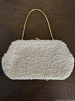 Front view of beaded clutch showing overall design, handle and clasp