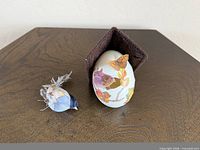 Egg ornament and separate blue bird displayed on tabletop