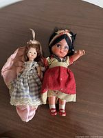 Both dolls lying on table