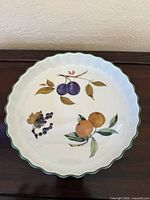 Top view showing entire quiche dish fruit motif and scalloped green rim