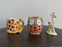 Front view of mug, owl holder, giraffe figurine