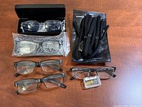 All items laid out: five eyeglasses, black hard case, leopard case in plastic, Shinko strap pack, repair kit