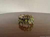 Full view of bracelet standing to show continuous leaf motif