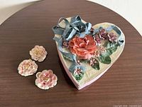 Heart-shaped jewelry box with seashell roses beside it
