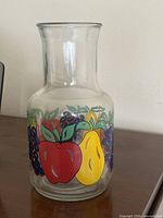 Full view of glass carafe showing fruit graphics and shape