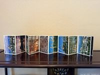 Front view of fully extended accordion postcard booklet showing eight color photo panels