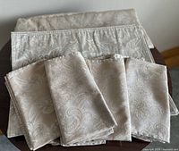 Folded tablecloth with stacked matching linens showing overall set