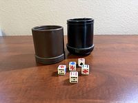 Brown and black dice cups with five poker dice