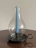 Front view of glass hurricane candleholder on metal base