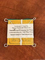 Back label showing handmade in Nepal information on yellow top flag