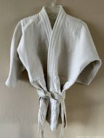 Full front view of judo gi jacket on hanger showing overall condition and design