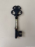 Full view of cast iron key thermometer on wall