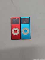Front view of red and blue Apple iPod Nanos showing screens and click wheels