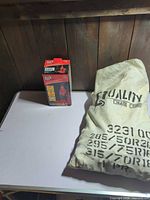 Boxed Torin Big Red bottle jack beside bag of Quality Chain Corp tire chains