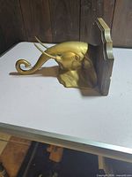 Side view of brass elephant head wall hanger showing trunk hook and plaque backplate