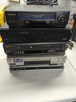 Stack of five video players showing fronts and brands