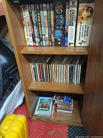 Overview of cabinet showing DVDs on top shelf, CDs on middle shelf, cassettes on bottom