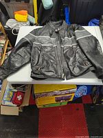 Front view of black leather motorcycle jacket on table