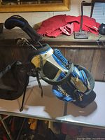 Side view of Cleveland junior stand bag displaying colors, straps and stand legs
