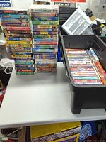 Overview of tote and stacked VHS tapes on table