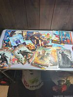 Variety of DVD discs spread on table showing multiple titles