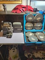 Projector, cover, cord, blue case with film reels
