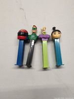 Four Pez dispensers laying side-by-side