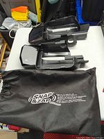 Two Snap & Zap mirror housings with storage bag on table