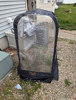 Front view of black snow blower cab with clear vinyl panel