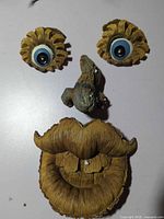Four resin pieces shaped as eyes, nose and mouth forming a tree face