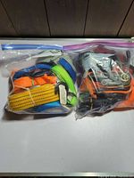 Two ziplock bags filled with assorted tie-down straps
