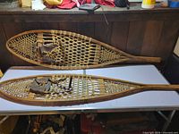 Full view of both wooden snowshoes on table