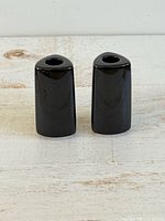 Front view of both glossy black triangular candlestick holders