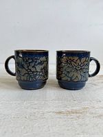 Front view showing both blue floral stacking mugs