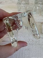 Underside view of one glass cube candle holder showing footed legs and texture