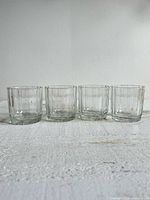 Front view of four identical ribbed lowball glasses