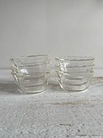 Two stacks of three clear glass bowls on surface