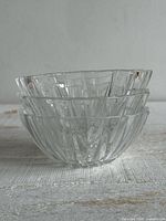 Three stacked clear ribbed glass bowls