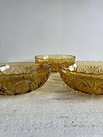 Three honey gold glass bowls side by side