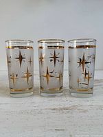 Three matching Dominion Atomic Starburst glasses front view