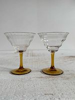 Both glasses front view showing clear bowls and amber stems