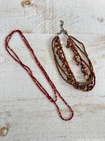 Two necklaces laid flat showing full lengths and bead styles
