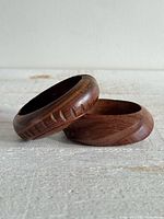 Two carved wooden bangles stacked showing overall form and wood grain