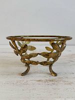 side view of brass bowl holder showing leaf design and feet